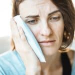 Woman with jaw pain - hypnotherapy training for healthcare professionals