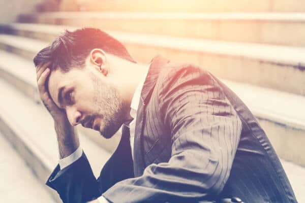 Therapy client sat on stairs, looking unmotivated and upset.