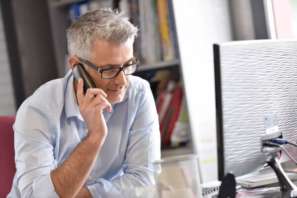 Getting hypnotherapy clients - image of a man with a phoen contact checkup update progress man working computer phone mobile job