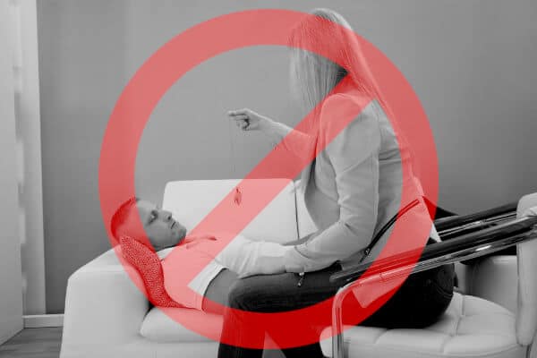 Woman performing a progressive induction with a pocket watch, a red stop sign stamped over the image, as she should be using a rapid induction